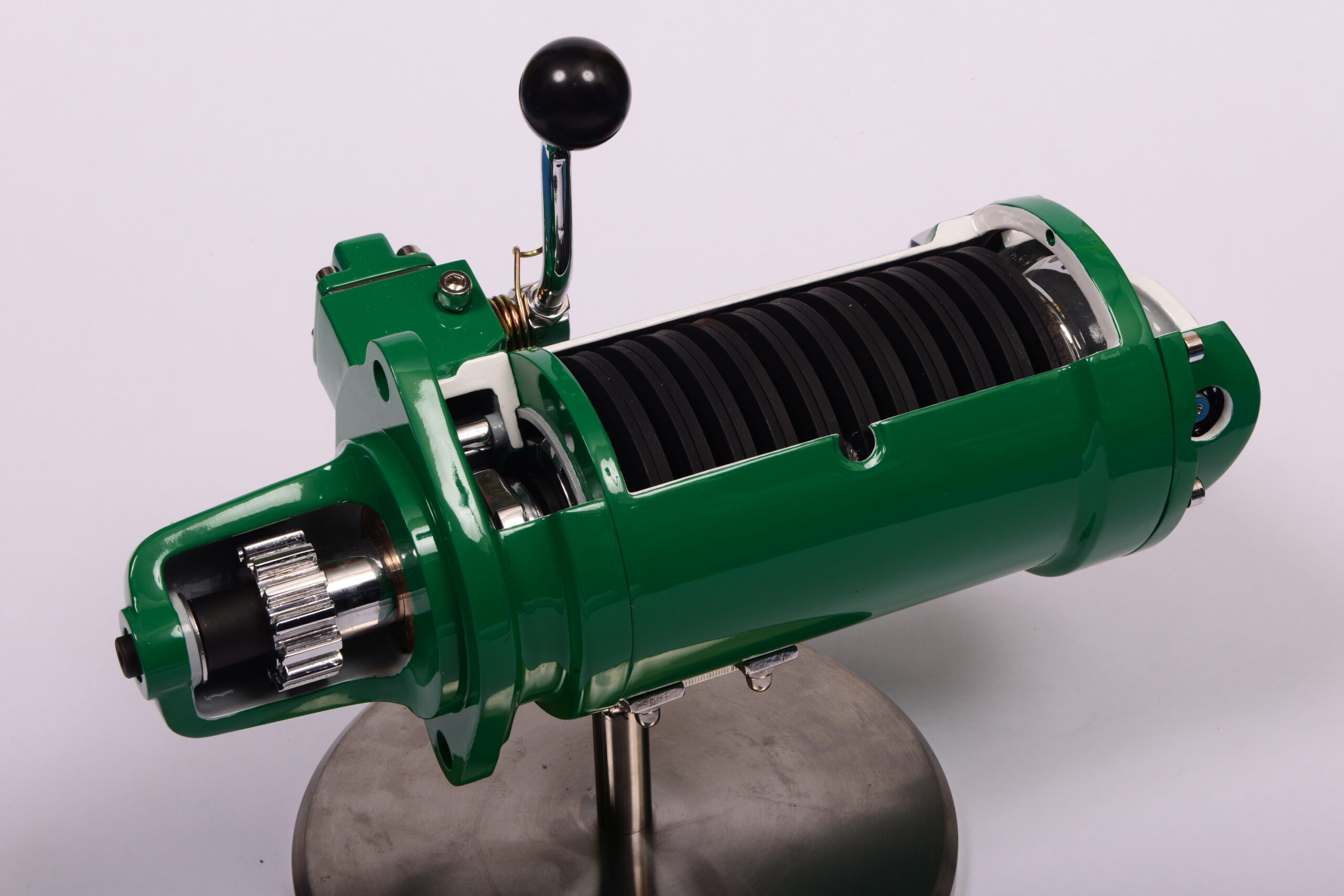Cutaway of a spring starter showing the coiled spring and pinion gear that cranks the engine
